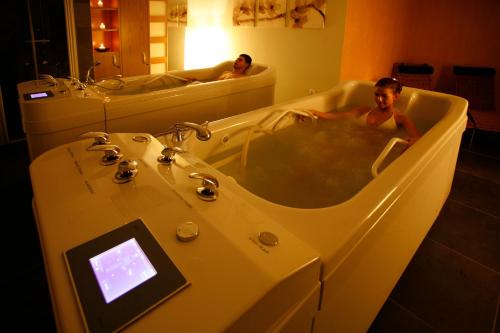 two men in a bath tub in a bathroom at Hotel Abácie & Wellness in Valašské Meziříčí