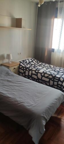 a bedroom with two beds and a window at Ciudad de Sada in Sada