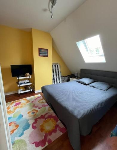 - une chambre avec un lit, une télévision et un tapis dans l'établissement Vacances, à Pornichet