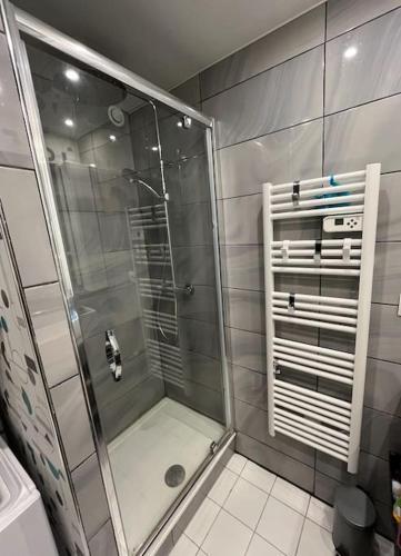 une douche avec une porte vitrée dans une salle de bain dans l'établissement Vacances, à Pornichet