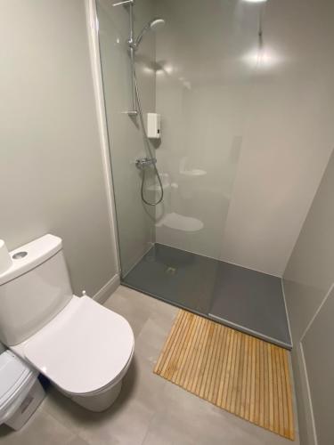 a bathroom with a shower and a white toilet at Heyday Hostel Ballina in Ballina