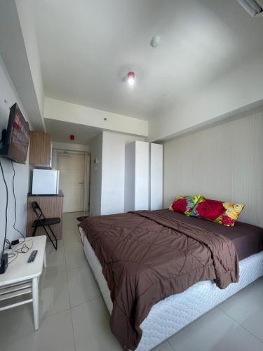 a bedroom with a large bed and a television at Apartment Anderson Benson Orchard Tanglin Tower di atas Pakuwon Mall Surabaya Barat in Lontar