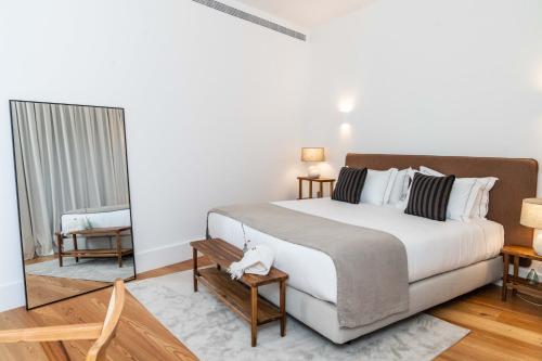 a bedroom with a large bed and a mirror at The Farm - Azores Boutique House in Ponta Delgada