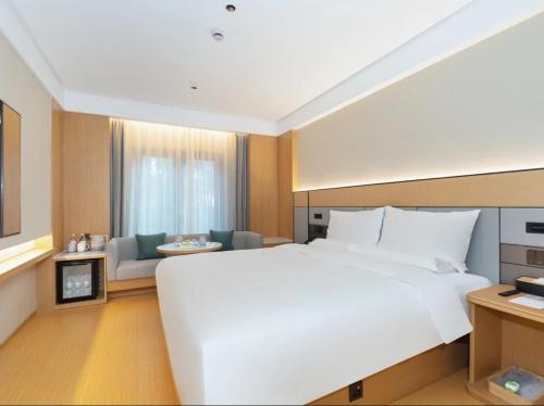 a large white bed in a hotel room at JI Hotel Shanghai International Tourism Chongxi Road in Nanhui