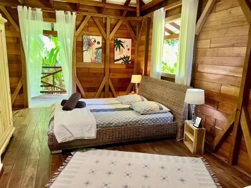 a room with a bed in a wooden cabin at Villa California 4 chambres 8 à 11 pers Vue mer in Deshaies