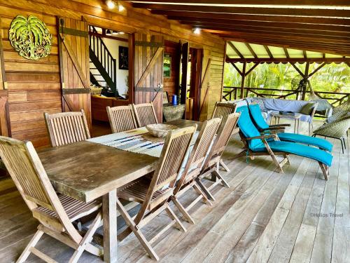 a wooden dining table and chairs on a deck at Villa California 4 chambres 8 à 11 pers Vue mer in Deshaies