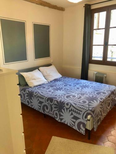 une chambre avec un lit avec une couverture bleue et blanche dans l'établissement Calme et idéalement placé, à Avignon