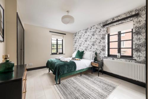 a bedroom with a bed with a green blanket at Salthouse Cottage in Ironbridge in Telford