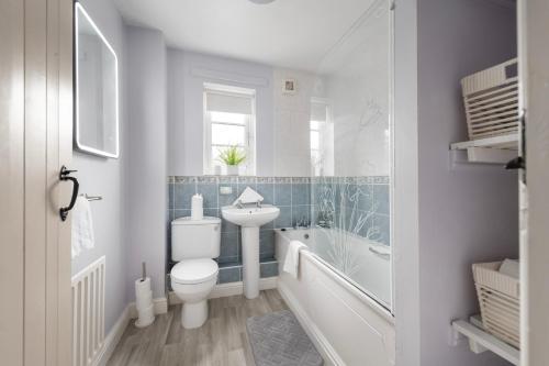 a bathroom with a toilet and a tub and a sink at Salthouse Cottage in Ironbridge in Telford