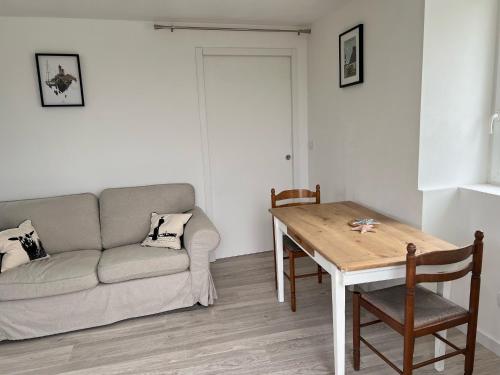 un salon avec un canapé et une table dans l'établissement TY MEIN gîte, à Lampaul