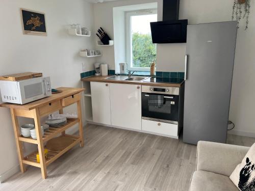 La cuisine est équipée d'un réfrigérateur, d'un évier et d'un four micro-ondes. dans l'établissement TY MEIN gîte, à Lampaul