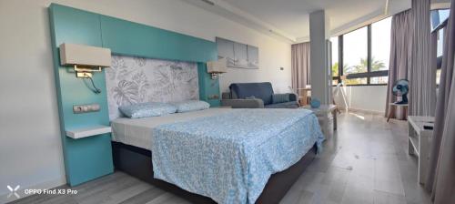 a bedroom with a bed and a blue wall at Sunrise Apartamentos in San Bartolomé