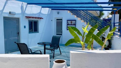 a patio with chairs and a table and stairs at Iris Studios in Archangelos