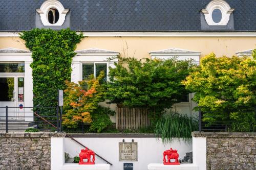 a house with red fire hydrants in front of it at Villa Kerasy Hotel Spa in Vannes