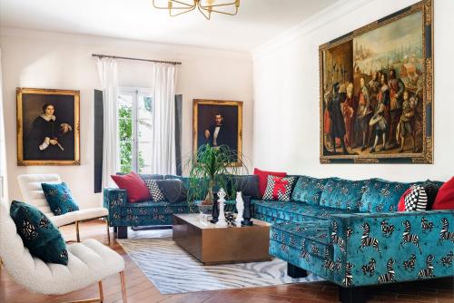 a living room with a blue couch and a painting at Cortijo Torre De La Reina in Torre de la Reina