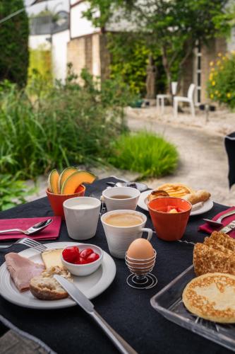 a table with plates of food and bowls of fruit at Villa Kerasy Hotel Spa in Vannes