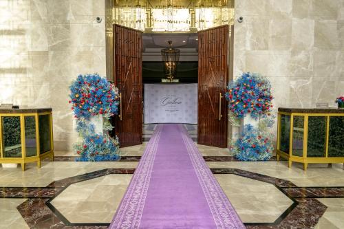 a purple aisle in a hotel lobby with a stage at The Hotel Galleria Jeddah, Curio Collection by Hilton in Jeddah