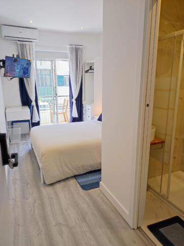 a bedroom with a white bed and a window at Vista Panorâmica Amadora Central in Amadora