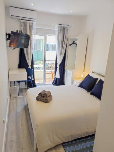 a bedroom with a bed with two slippers on it at Vista Panorâmica Amadora Central in Amadora