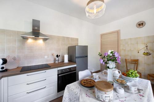 a kitchen with a table and a refrigerator at Chez Sabrina in Champdepraz