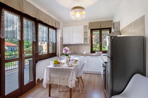a kitchen with a table and a refrigerator at Chez Sabrina in Champdepraz