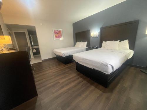 a hotel room with two beds and wooden floors at Motel 6 Norfolk, VA East Little Creek in Norfolk