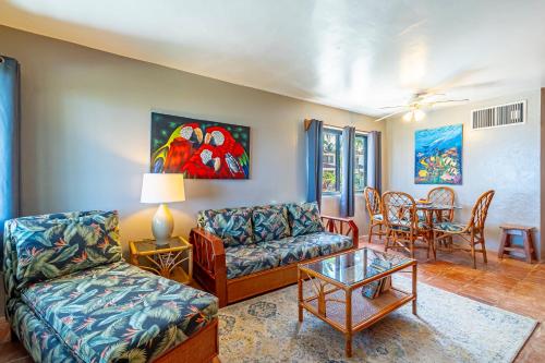 a living room with a couch and a table at Tradewinds Paradise Villas in San Pedro