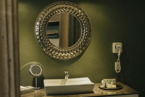 a bathroom with a sink and a mirror at Hotel Boutique de Cantera Y Plata in Taxco de Alarcón
