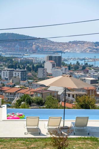 a pool with two chairs and an umbrella at Uphill Glavanovic Villas in Bar