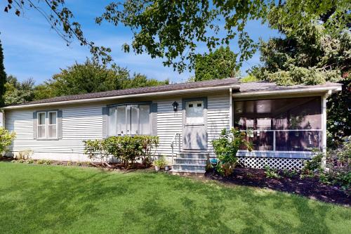 a small white house with a yard at Rehoboth Beach --- Harper's Nest - 103 Truitt Ave in The Plantations