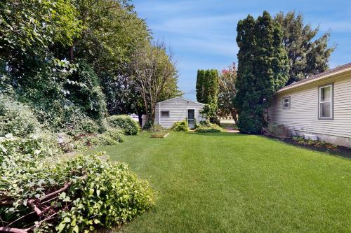 a yard next to a house with a grass yard at Rehoboth Beach --- Harper's Nest - 103 Truitt Ave in The Plantations