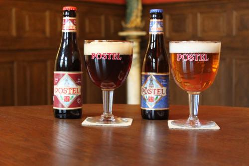 two bottles of beer and two glasses on a table at B&B Molmento in Mol