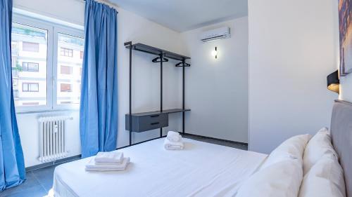 a bedroom with a bed and a window with blue curtains at EasyTopStay - Gelsomino Charming Flat in Rome