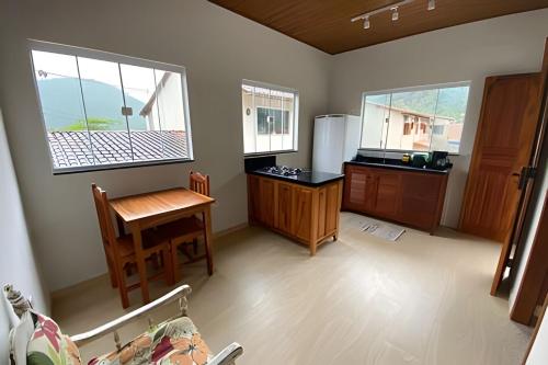 a kitchen with a table and a refrigerator at Linda Casa C/ Vista pro Mar na Praia Grande em Paraty in Paraty