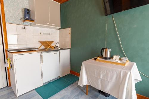 une petite cuisine avec une table dans une pièce dans l'établissement La Rosée - Studio Cosy à 50m des Thermes - Vue jardin, Wifi, Smart TV, à Bourbonne-les-Bains