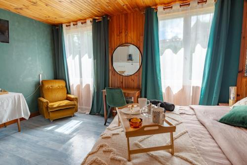 une chambre avec un lit, une table et une chaise dans l'établissement La Rosée - Studio Cosy à 50m des Thermes - Vue jardin, Wifi, Smart TV, à Bourbonne-les-Bains