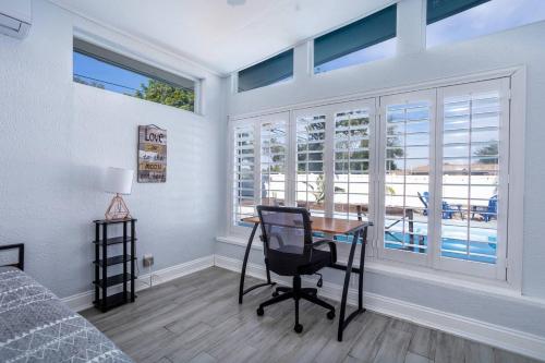 a bedroom with a desk with a chair and windows at 2br Family Retreat Orlando Full Kitchen in Orlando
