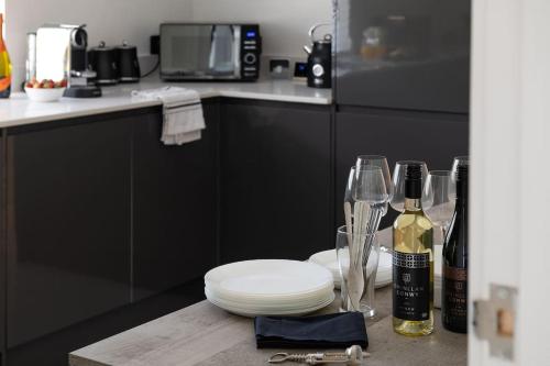 a kitchen with a counter with plates and wine glasses at Pencraig Cottage Indoor Hot Tub in Amlwch