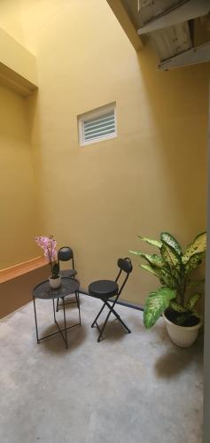 two chairs and a table in a room with plants at Pomah Guesthouse in Jatingaleh