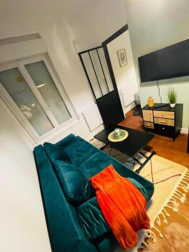 un salon avec un canapé bleu et une table dans l'établissement L'Escapade avec salle de sport, à Amiens