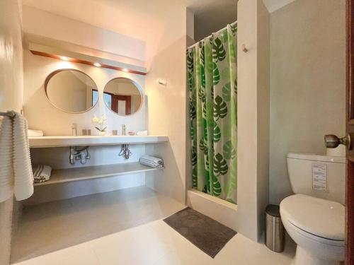 キャバレテにあるCharming ocean front 3 bd villaのトイレ、洗面台、鏡を備えたバスルーム