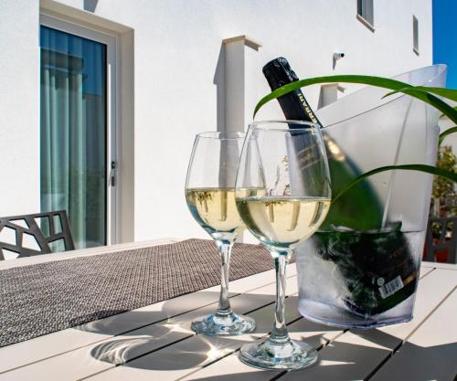 two glasses of white wine sitting on a table at Ferrari Rooms & Apartments in Porto Cesareo