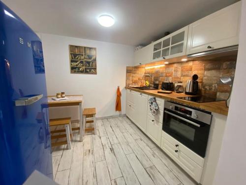 une cuisine avec des armoires blanches et une table à l'intérieur dans l'établissement Le Nid, à Vence