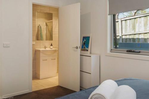 1 dormitorio con baño con lavabo y espejo en Sunny Retreat in Kingston Beach, en Kingston Beach