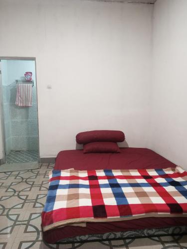 a bed with a colorful blanket on it in a room at Zian guest house in Seganteng