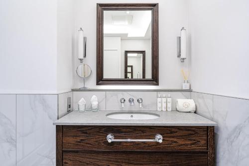 a bathroom with a sink and a mirror at RÌGH Residences - George Street in Edinburgh