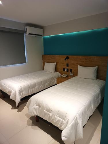 Ένα ή περισσότερα κρεβάτια σε δωμάτιο στο Hotel Kavia Mazatlán