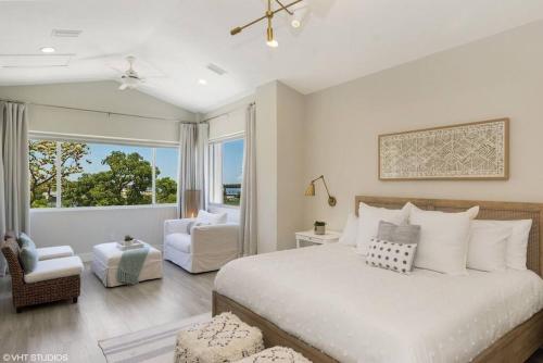 a bedroom with a large white bed and a chair at Mariners 212 Great Location with Marina Views in Key Largo
