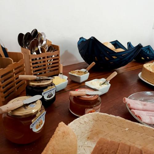 a table topped with jars of butter and bread at Pousada Oceano Atlântico in Marau
