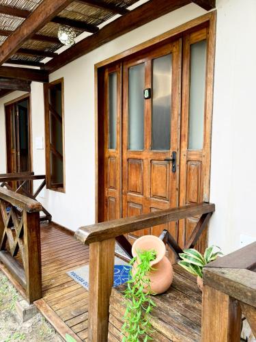 a porch with a wooden door and a potted plant at Pousada Oceano Atlântico in Marau